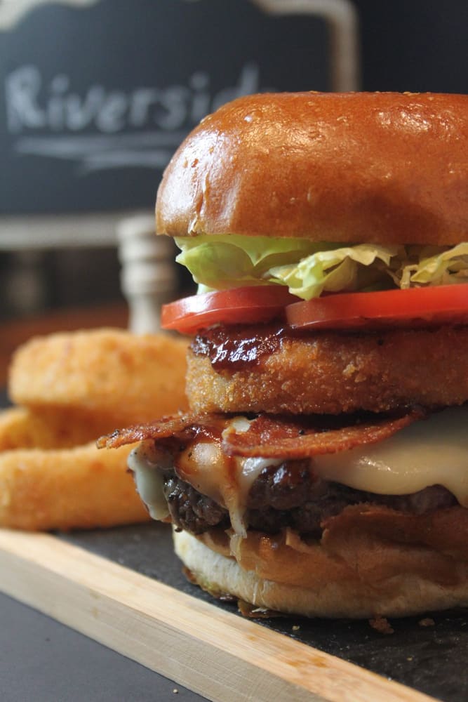 The Riverside burger with bacon, lettuce and tomato, chalkboard behind