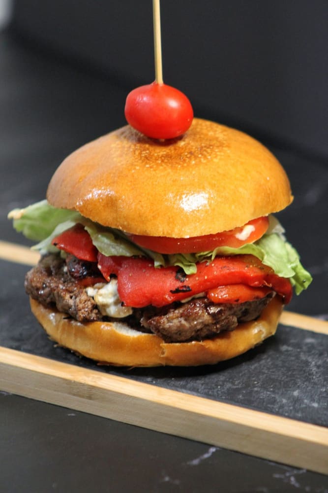 Lamb burger with roasted red peppers, served on slate